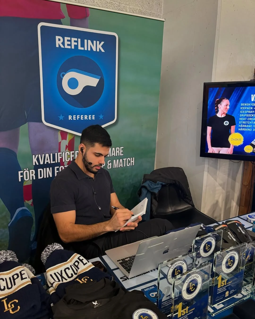 Reflink-representant med headset, anteckningar och laptop i Luxcuper-miljö